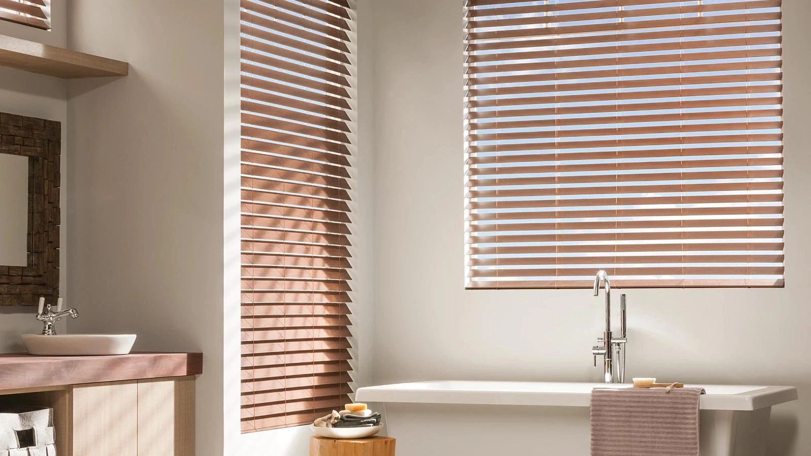 Wood-toned Alta faux-wood blinds beside a bathtub.